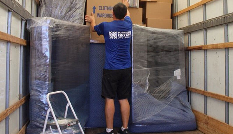 Licensed movers load a two-bedroom apartment for a move.