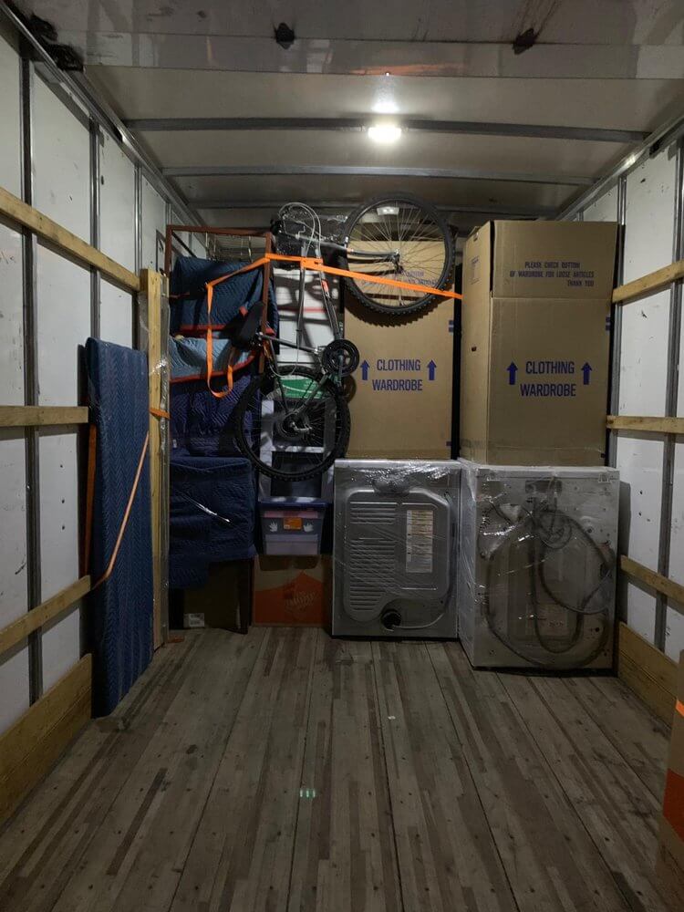 Neatly packed moving truck with college student belongings, including boxes, bikes, and appliances, ready for relocation in Los Angeles