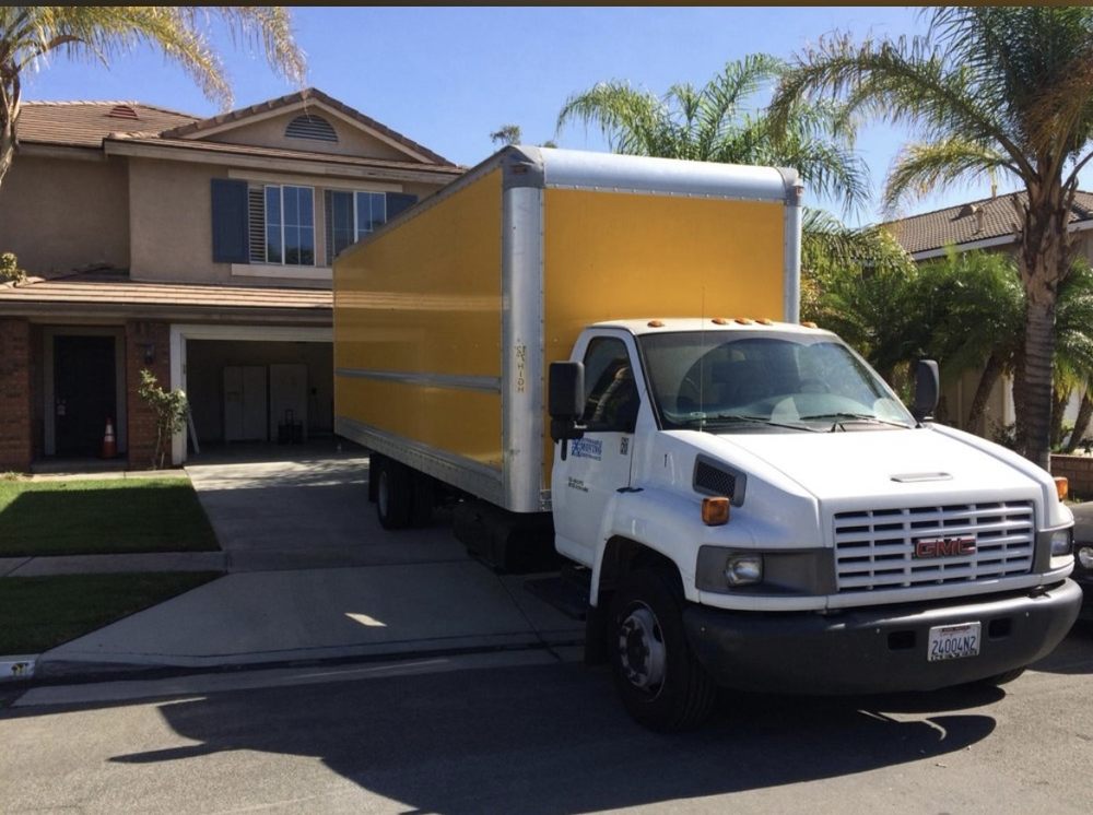 Large yellow and white moving truck parked in front of a Los Angeles home, ready for exercise equipment relocation